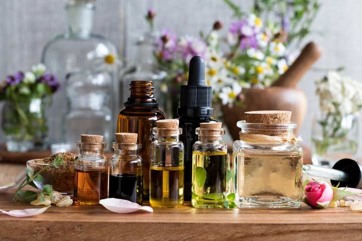 What are the key differences between organic and conventional essential oils in terms of production methods and sourcing?